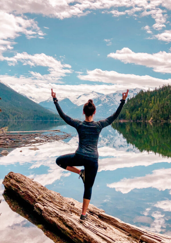 Woman doing yoga tree pose at Cheakamus Lake in Whistler